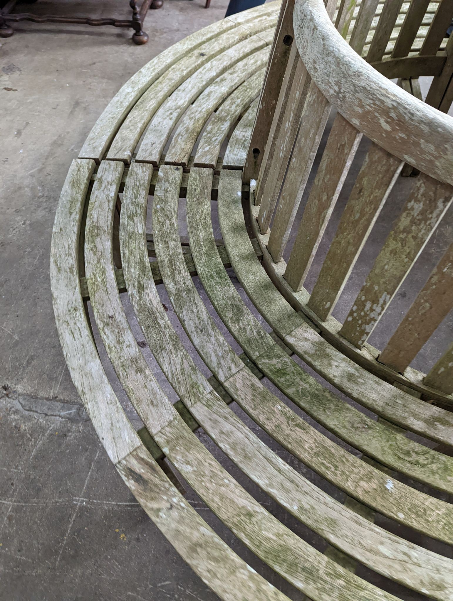 A weathered teak four section tree seat, aperture 90cm diameter, the seat 200cm diameter, height 90cm